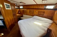 1990 Trader 41 + 2 Sundeck yacht cabin with wooden interior and cozy bed.