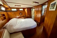 Luxurious 1990 Trader 41 + 2 Sundeck yacht cabin with wood paneling and cozy bed.
