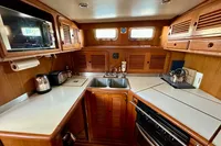 1990 Trader 41 + 2 Sundeck yacht kitchen with wooden cabinets and modern appliances.