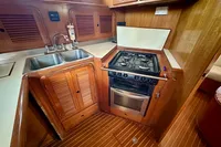 1990 Trader 41 + 2 Sundeck yacht kitchen with stove, sink, and wooden cabinetry.