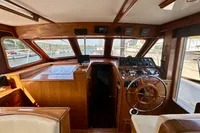 Interior of 1990 Trader 41 + 2 Sundeck yacht with wooden helm and navigation equipment.