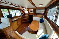 Interior of 1990 Trader 41 + 2 Sundeck yacht with wood finish and cozy seating area.