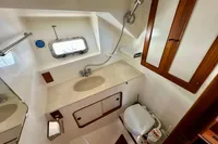 1990 Trader 41 + 2 Sundeck yacht bathroom with sink, toilet, and showerhead.