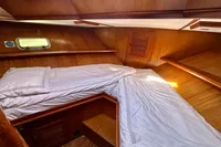 Cozy cabin interior of 1990 Trader 41 + 2 Sundeck yacht with wooden finish and bedding.