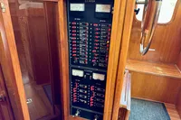 Electrical panel on 1990 Trader 41 + 2 Sundeck boat, featuring gauges and switches in wooden cabinet.