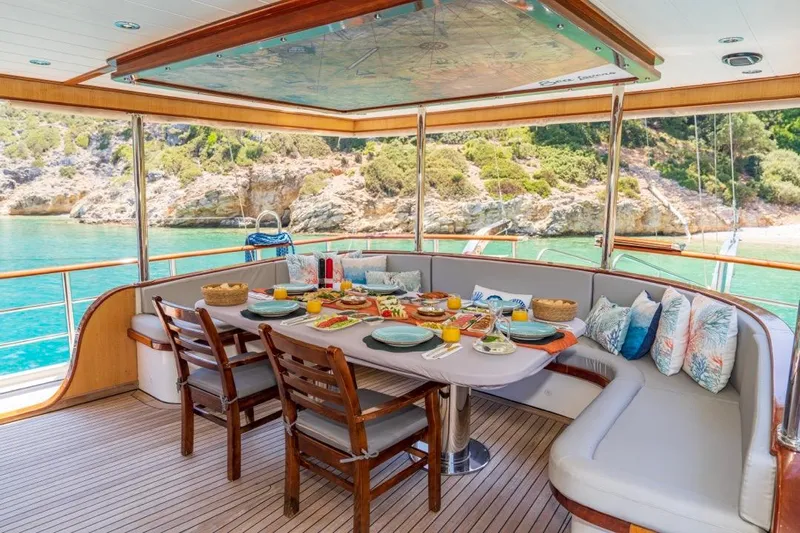  Yacht Photos Pics Luxurious dining area on a 2022 Gulet 24m yacht, overlooking serene turquoise waters.