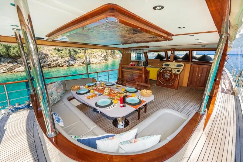  Yacht Photos Pics Luxurious 2022 Gulet 24m yacht interior with elegant dining setup and scenic ocean view.