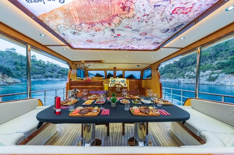  Yacht Photos Pics Luxurious dining setup on a 2022 Gulet 24m yacht, featuring elegant decor and scenic views.