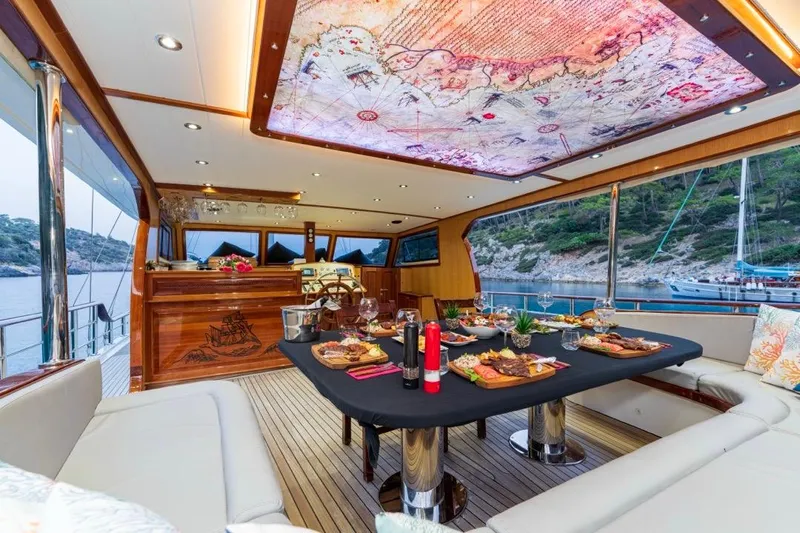  Yacht Photos Pics Luxurious 2022 Gulet 24m yacht interior with elegant dining setup and scenic ocean view.