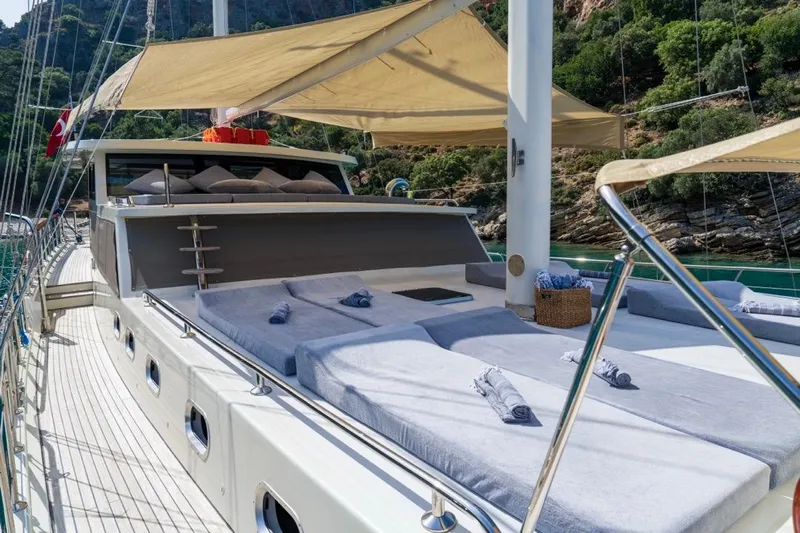  Yacht Photos Pics Luxurious 2022 Gulet 24m yacht with sunbathing deck, anchored in scenic coastal waters.