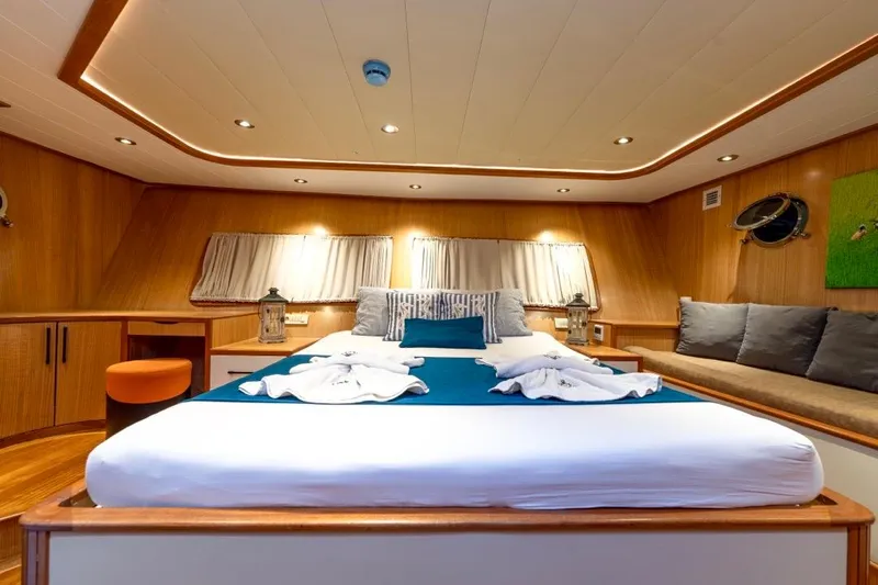  Yacht Photos Pics Luxurious 2022 Gulet 24m yacht cabin with elegant wood interior and cozy bedding.