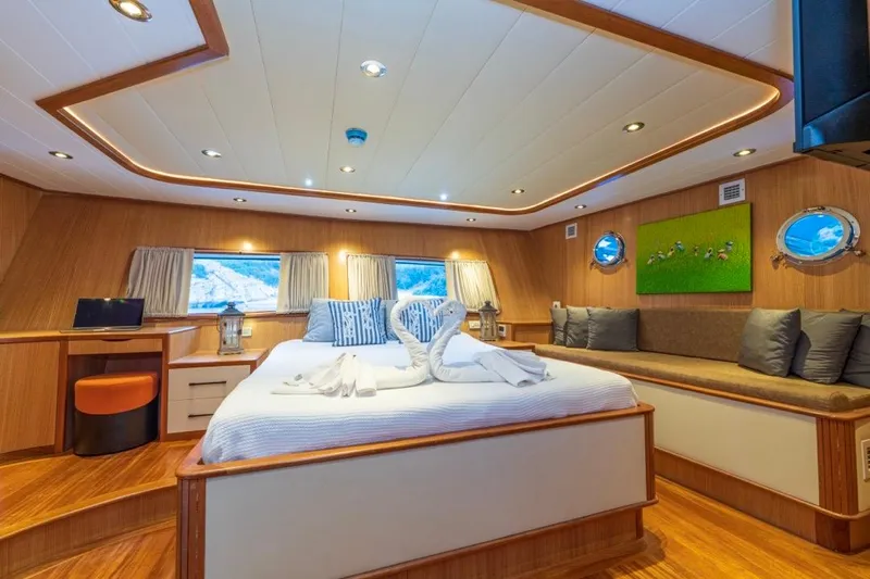  Yacht Photos Pics Luxurious 2022 Gulet 24m yacht cabin with elegant wood interior and cozy bedding.