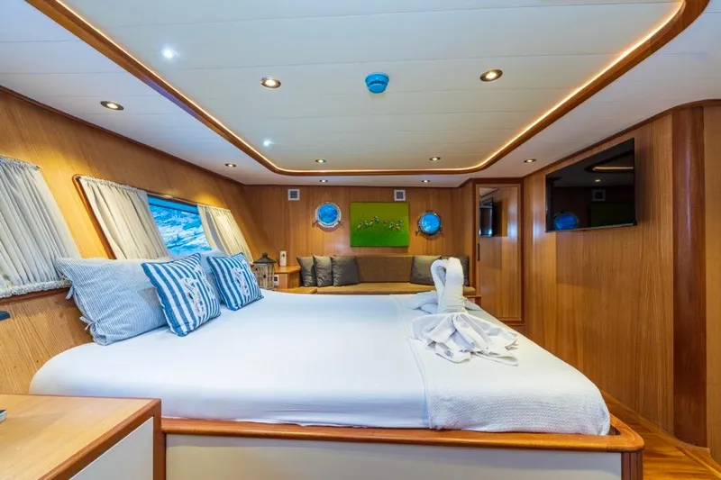  Yacht Photos Pics Luxurious 2022 Gulet 24m yacht cabin with elegant wood paneling and cozy bedding.