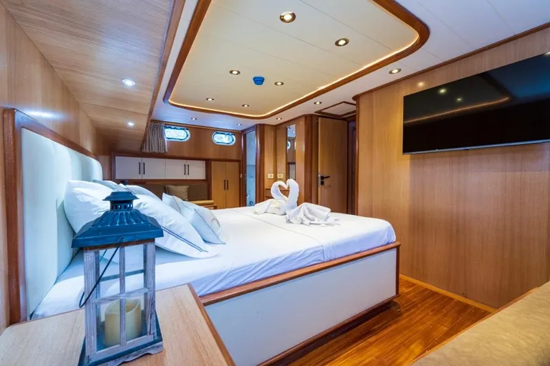  Yacht Photos Pics Luxurious Gulet 24m 2022 yacht cabin with elegant wood interior and cozy bedding.