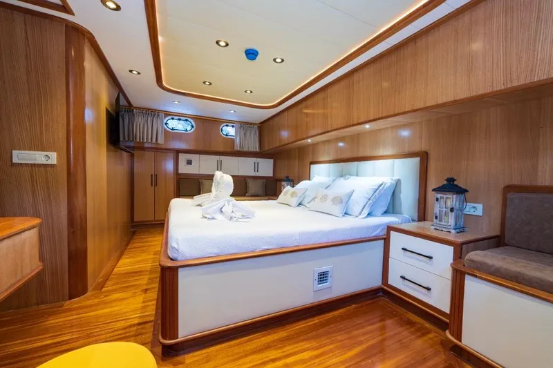  Yacht Photos Pics Luxurious 2022 Gulet 24m yacht cabin with elegant wood finish and cozy bedding.