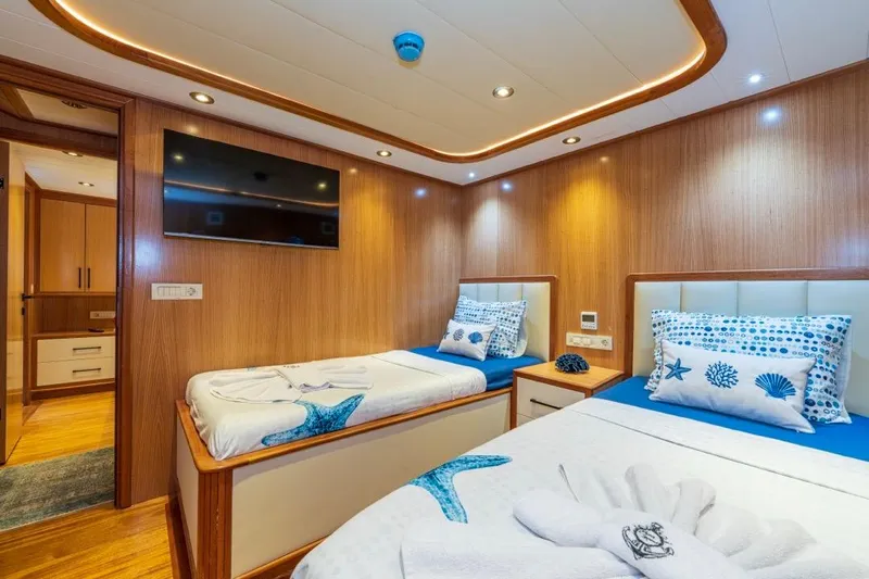  Yacht Photos Pics Luxurious 2022 Gulet 24m yacht cabin with twin beds, modern decor, and ambient lighting.