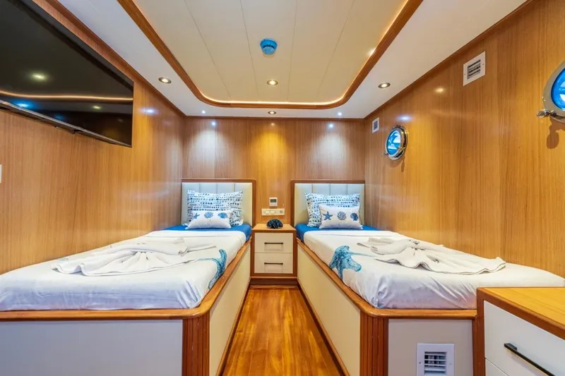  Yacht Photos Pics Luxurious twin cabin interior on 2022 Gulet 24 m yacht, featuring wood paneling and modern amenities.