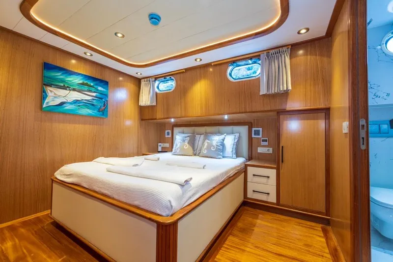  Yacht Photos Pics Luxurious Gulet 24m yacht bedroom, 2022 model, featuring elegant wood paneling and modern decor.