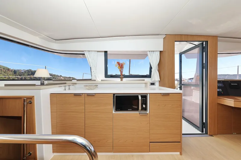 Belle Amie Yacht Photos Pics Modern kitchen interior on 2025 Bali 4.6 yacht with wood cabinetry and panoramic windows.