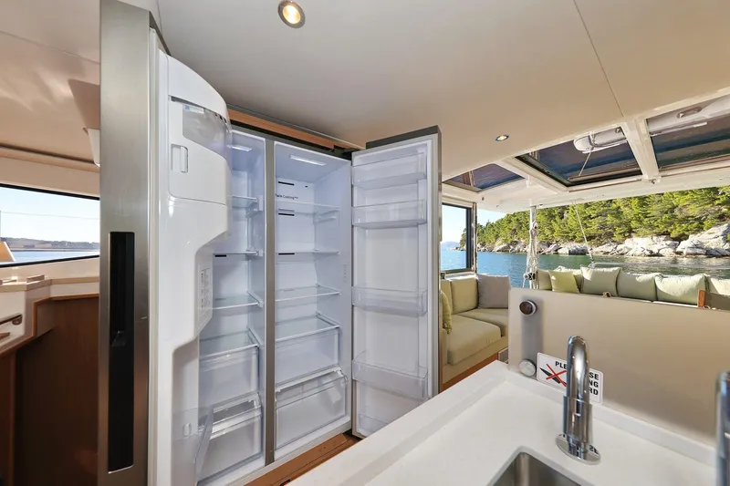 Belle Amie Yacht Photos Pics Luxurious Bali 4.6 yacht interior with open fridge, modern kitchen, and scenic ocean view, 2025 model.