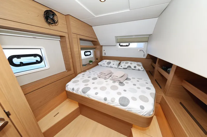 Belle Amie Yacht Photos Pics Luxurious cabin interior of 2025 Bali 4.6 yacht with cozy bed and wooden finish.