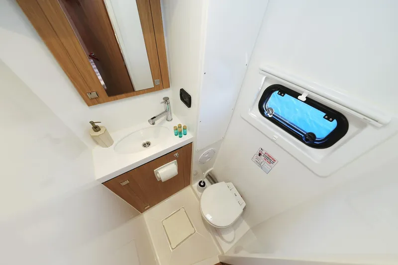 Belle Amie Yacht Photos Pics Modern bathroom in 2025 Bali 4.6 yacht with sink, toilet, and porthole window.