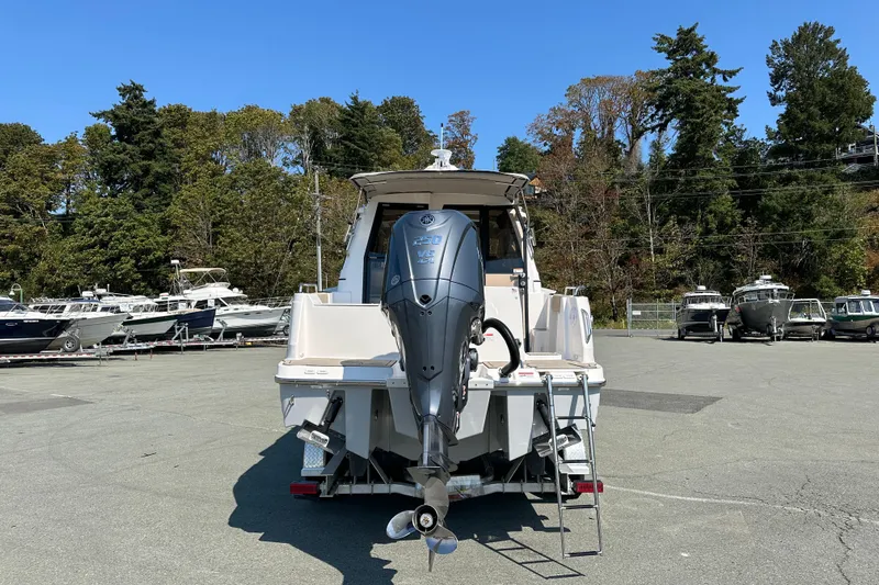  Yacht Photos Pics 2026 Cutwater C-248 Coupe boat with outboard motor, parked in a marina lot.