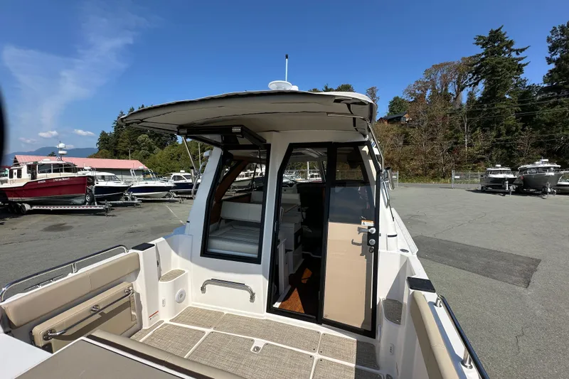  Yacht Photos Pics 2026 Cutwater C-248 Coupe boat exterior, docked with open cabin door, clear sky background.