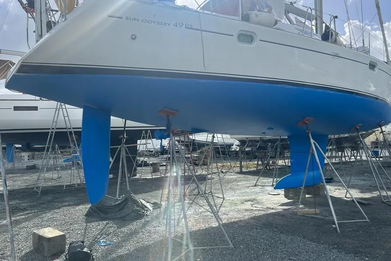 4 Estrellas Yacht Photos Pics 2006 Jeanneau Sun Odyssey 49 DS sailboat on stands, hull painted blue.