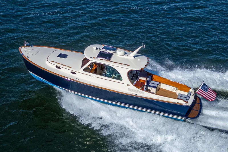 Gracious Yacht Photos Pics 2018 Hinckley Picnic Boat 37 MKIII cruising on open water, displaying sleek design and American flag.