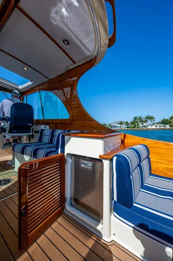 Gracious Yacht Photos Pics 2018 Hinckley Picnic Boat 37 MKIII with blue-striped seating and wooden interior, under clear blue sky.