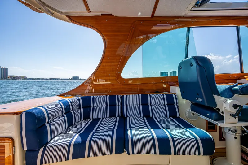 Gracious Yacht Photos Pics Luxurious interior of 2018 Hinckley Picnic Boat 37 MKIII with striped seating, overlooking the water.