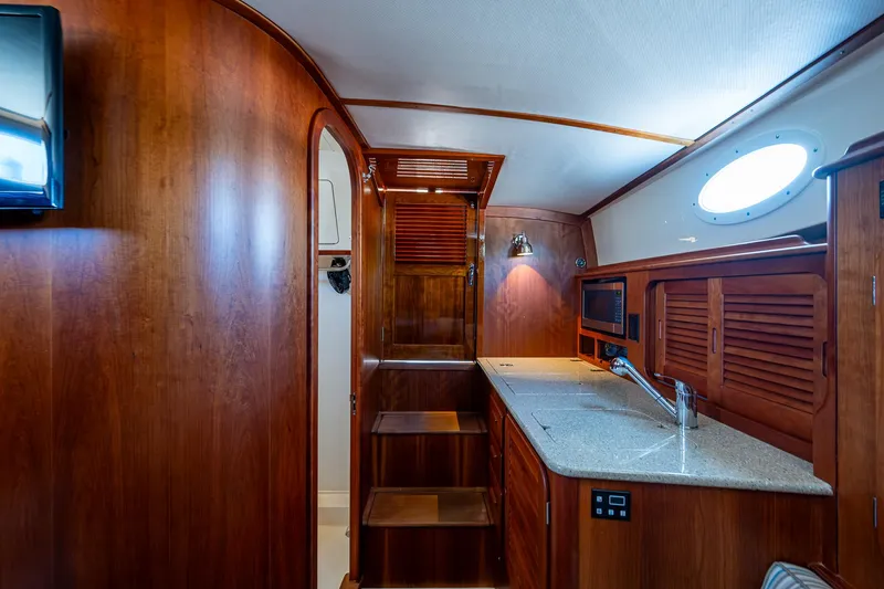 Gracious Yacht Photos Pics Interior of 2018 Hinckley Picnic Boat 37 MKIII with wooden cabinetry and modern amenities.