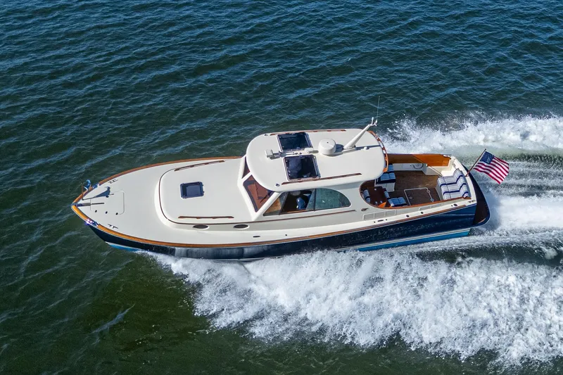 Gracious Yacht Photos Pics 2018 Hinckley Picnic Boat 37 MKIII cruising on open water, displaying sleek design and American flag.