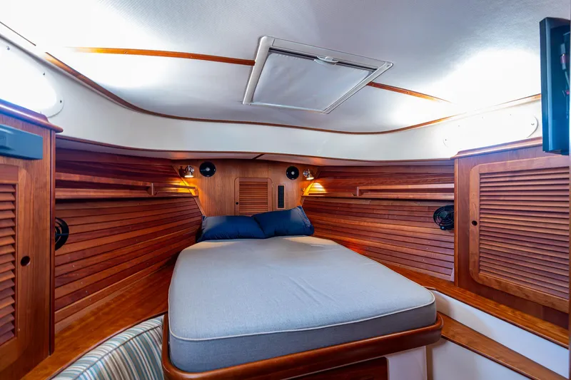 Gracious Yacht Photos Pics Luxurious cabin interior of 2018 Hinckley Picnic Boat 37 MKIII with wooden accents and cozy bed.