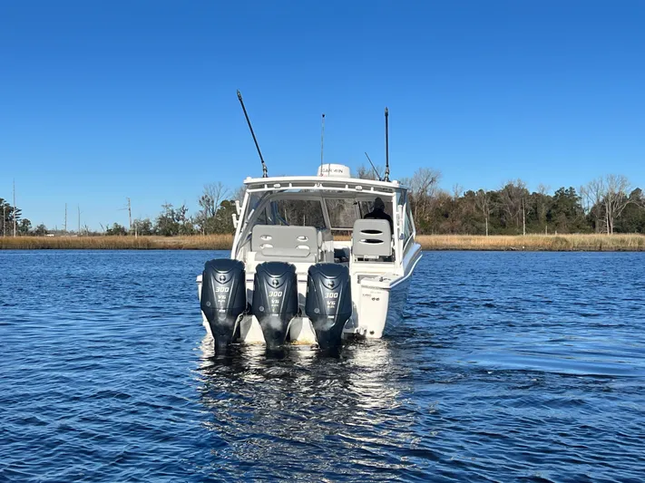  Yacht Photos Pics 2023 Albemarle 31 Dual Console boat with triple outboard engines on a calm lake.