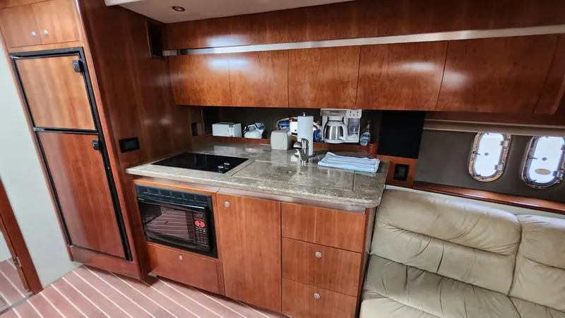  Yacht Photos Pics 2008 Cruisers Yachts 420 Express interior kitchen with wooden cabinets and modern appliances.