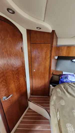  Yacht Photos Pics 2008 Cruisers Yachts 420 Express cabin interior with wooden door and cozy bedding.