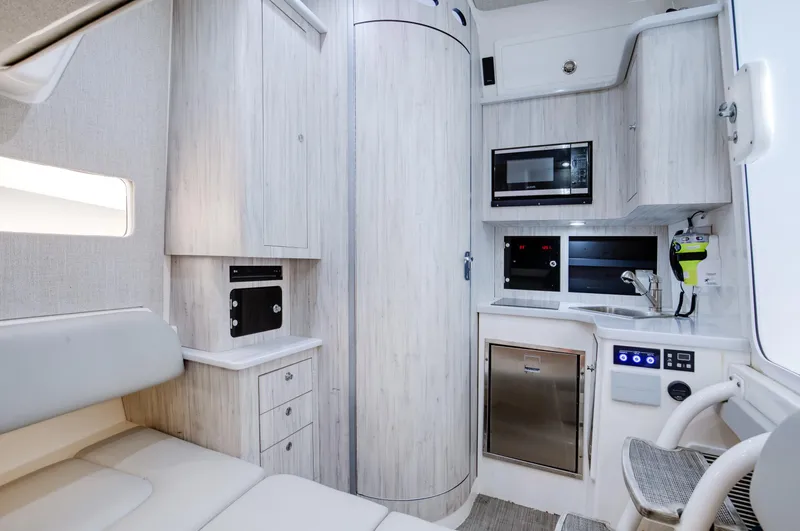  Yacht Photos Pics 2021 Regulator 41 interior with modern kitchen, light wood cabinetry, and seating area.