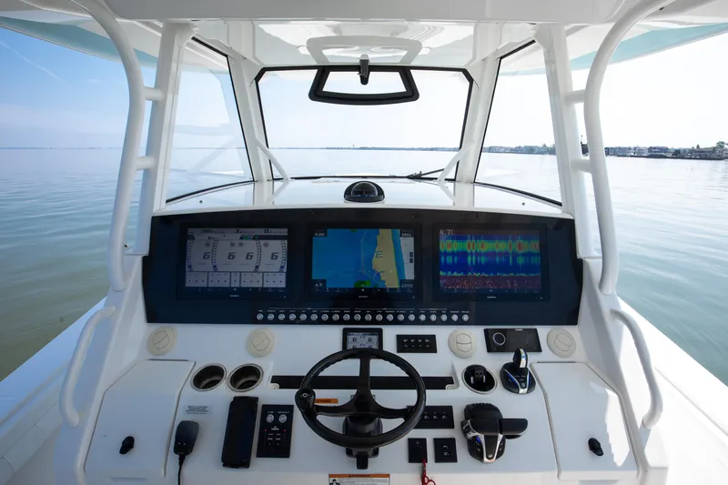  Yacht Photos Pics 2021 Regulator 41 boat helm with advanced navigation displays on calm water.