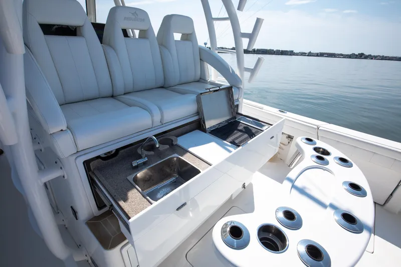  Yacht Photos Pics 2021 Regulator 41 boat interior with seating, sink, and rod holders on a sunny day.