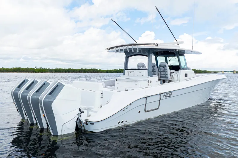  Yacht Photos Pics 2026 HCB 42 Lujo boat with four engines on calm water under a cloudy sky.