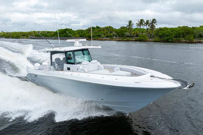  Yacht Photos Pics 2026 HCB 42 Lujo boat cruising on a scenic waterway with lush greenery.