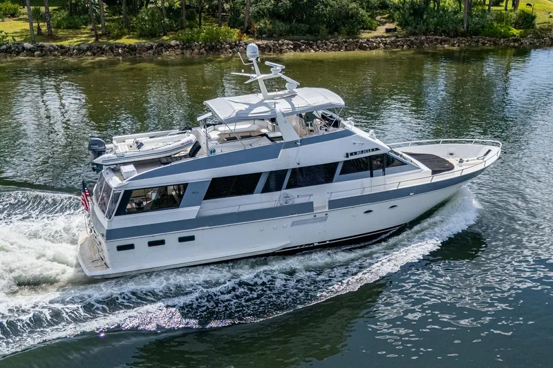 Mi Jule Yacht Photos Pics 1991 Viking 65 Motor Yacht cruising on a calm waterway, surrounded by lush greenery.