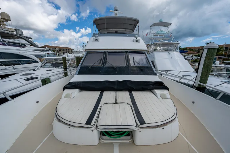 Mi Jule Yacht Photos Pics 1991 Viking 65 Motor Yacht docked at marina under cloudy sky.