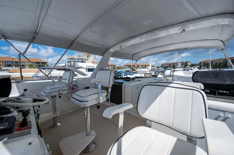Mi Jule Yacht Photos Pics 1991 Viking 65 Motor Yacht interior with white seating and helm, docked at marina.