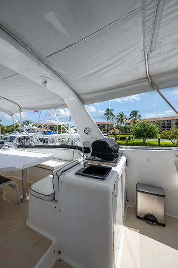 Mi Jule Yacht Photos Pics 1991 Viking 65 Motor Yacht deck with seating and grill, docked near palm trees.