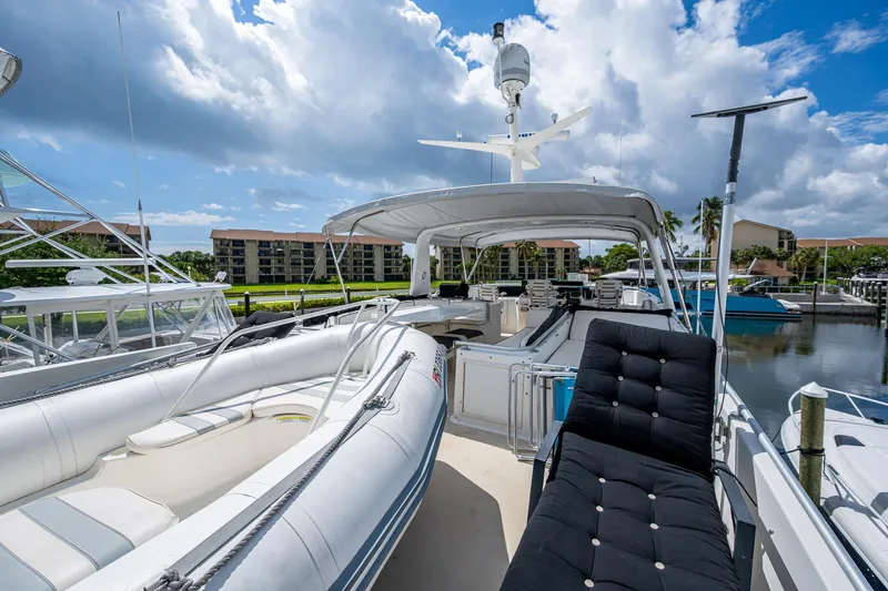 Mi Jule Yacht Photos Pics 1991 Viking 65 Motor Yacht deck with seating, docked under a partly cloudy sky.