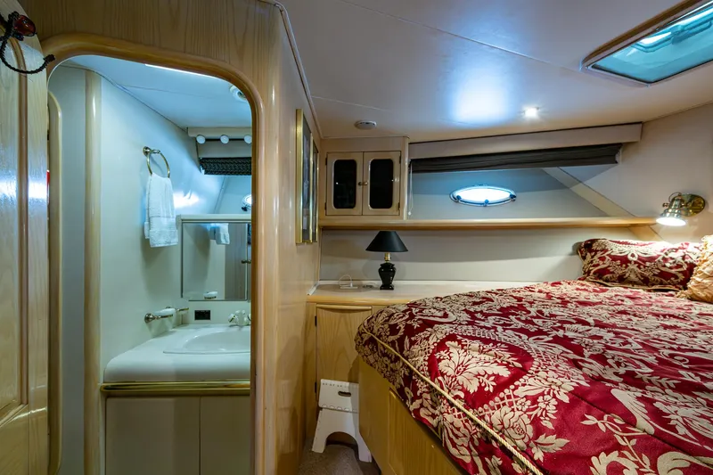 Mi Jule Yacht Photos Pics Luxurious bedroom and bathroom in a 1991 Viking 65 Motor Yacht, featuring elegant decor.