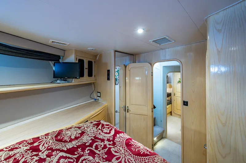 Mi Jule Yacht Photos Pics Interior of 1991 Viking 65 Motor Yacht bedroom with wood paneling and red patterned bedding.